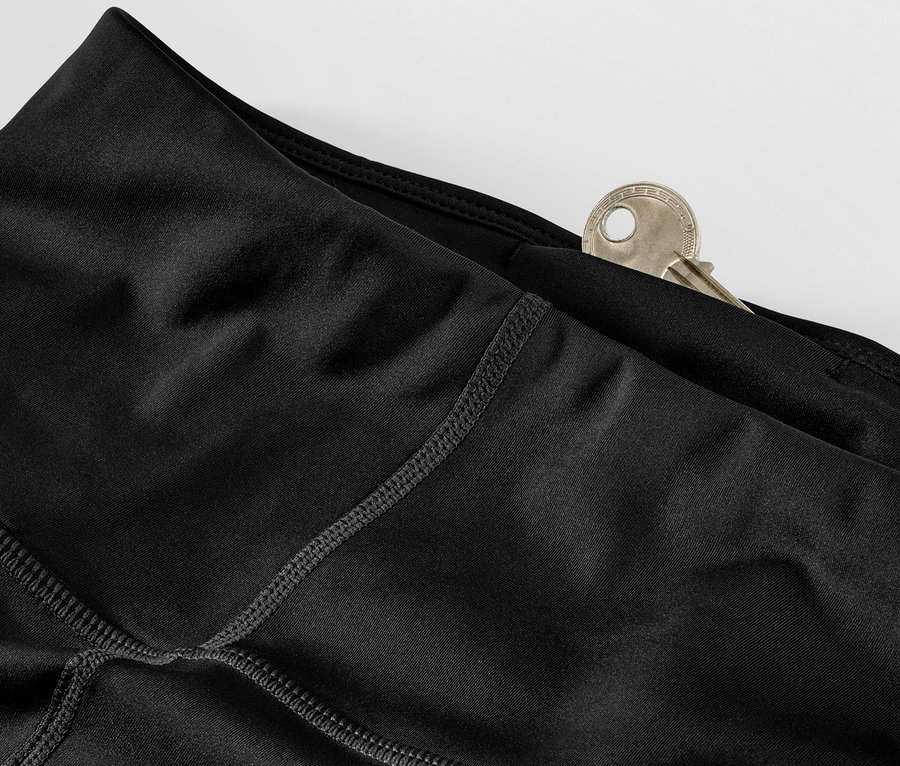 Detail einer schwarzen Sporttight mit einem Schlüssel in der Tasche.