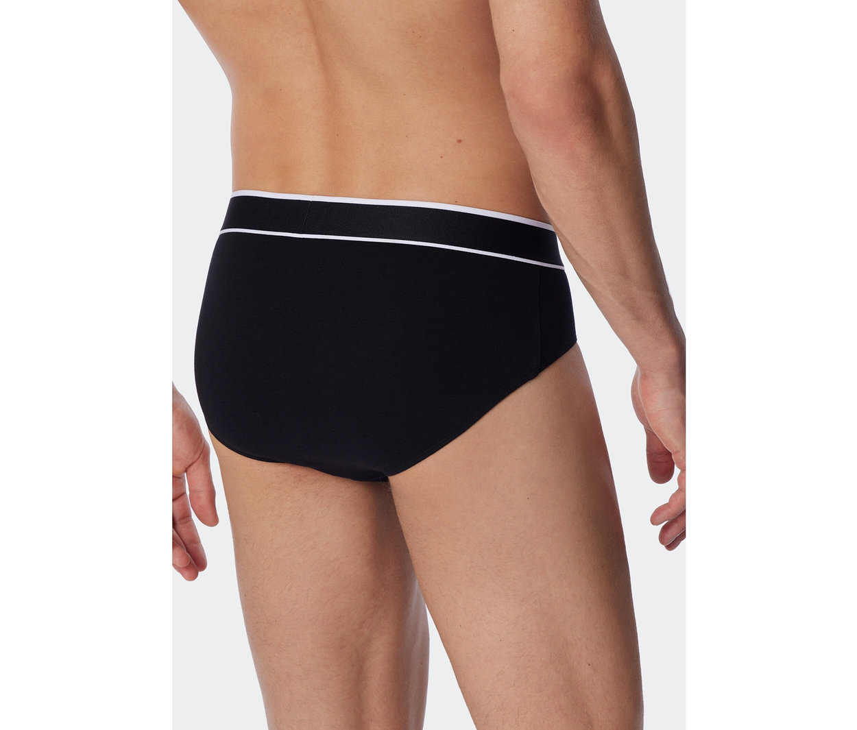 Ein Mann von hinten, der schwarze SCHIESSER Rio-Slips mit weißem Bund trägt.