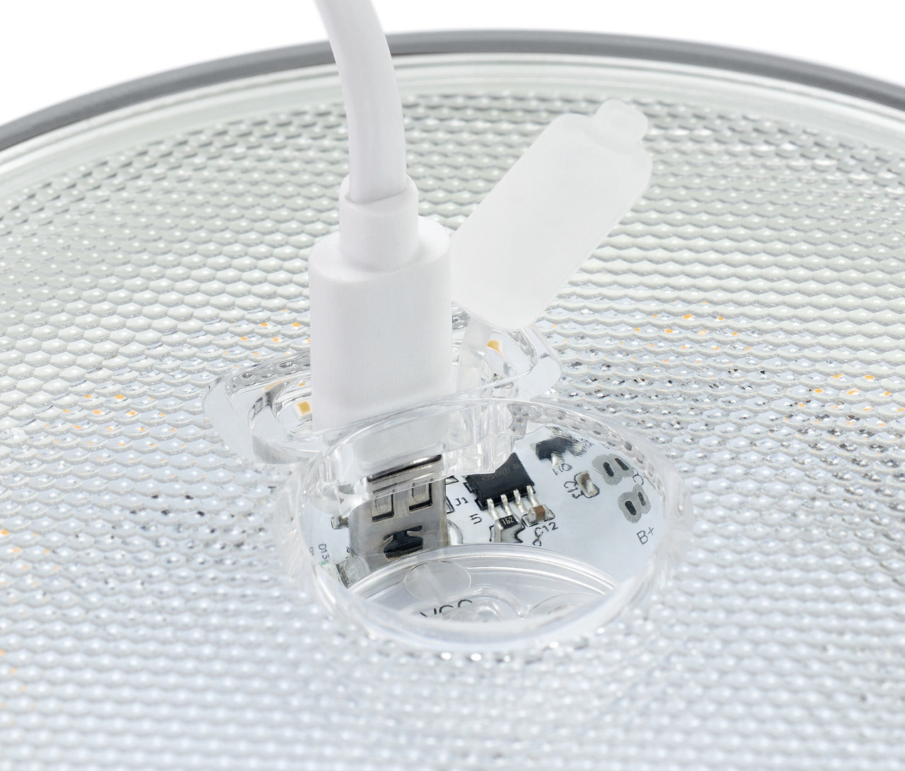 Detailaufnahme eines weißen USB-Steckers, der in eine transparente Buchse mit sichtbaren elektronischen Bauteilen eingesteckt ist.