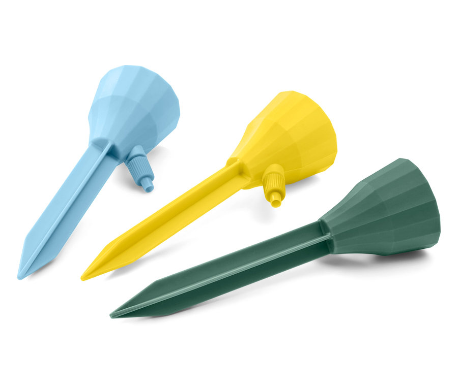 Drei automatische Bewässerungssticks in Blau, Gelb und Grün liegen auf weißem Grund.