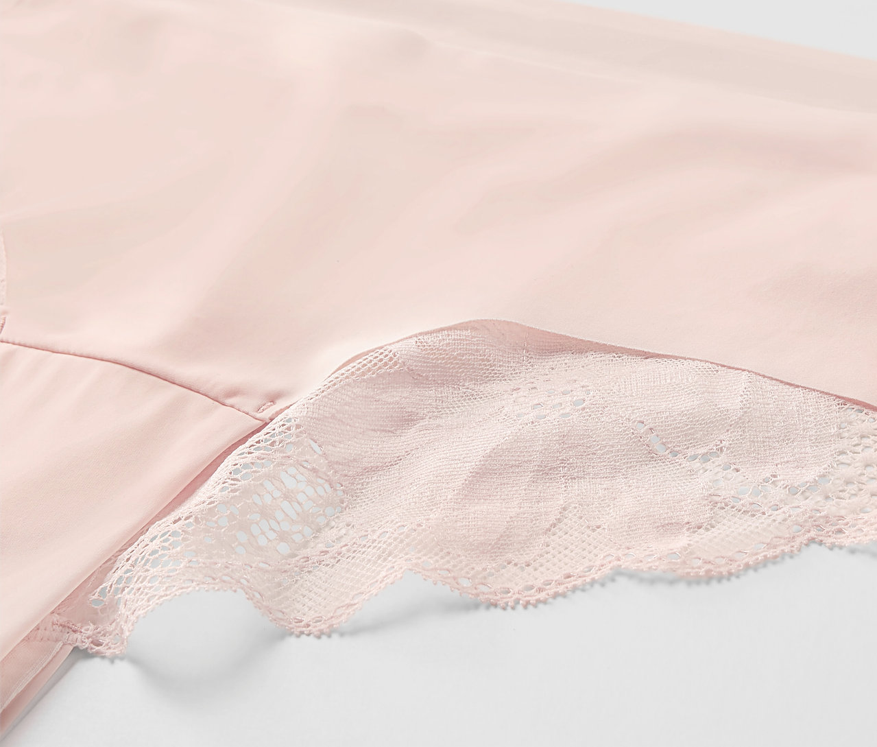 Detailaufnahme von roséfarbenen Magic-Cut-Brazil-Slips mit Spitze.