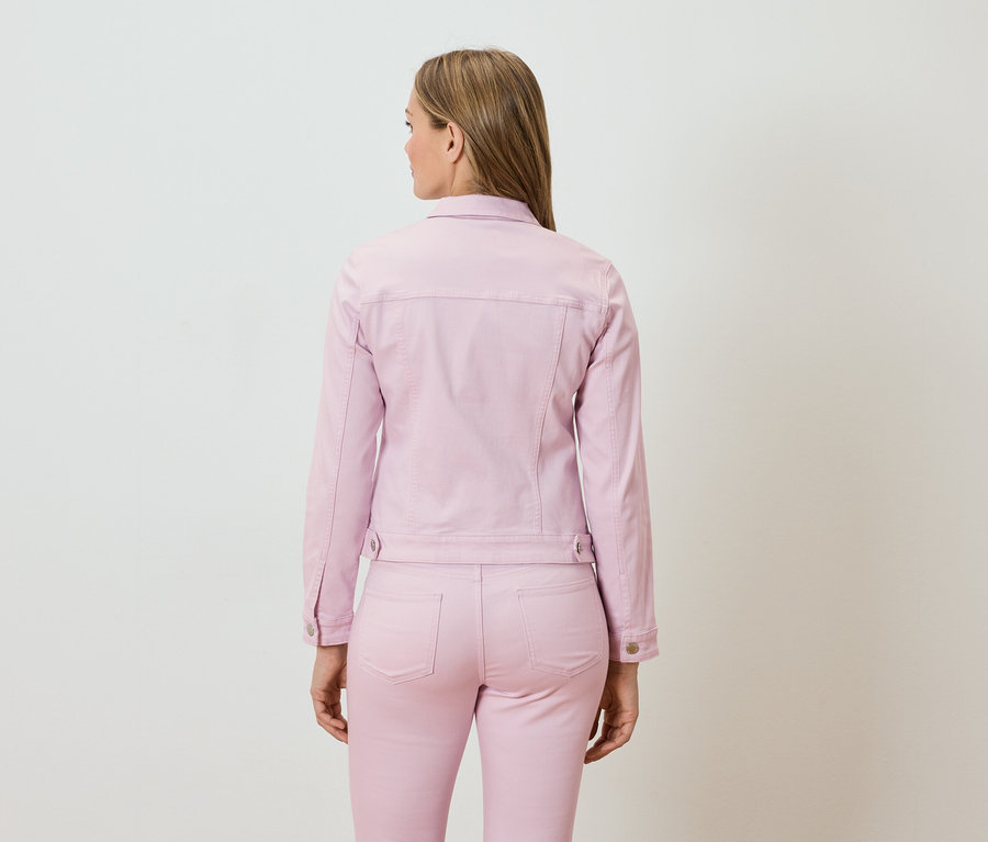 Frau von hinten, gekleidet in eine rosa Jeansjacke und passende Hose.