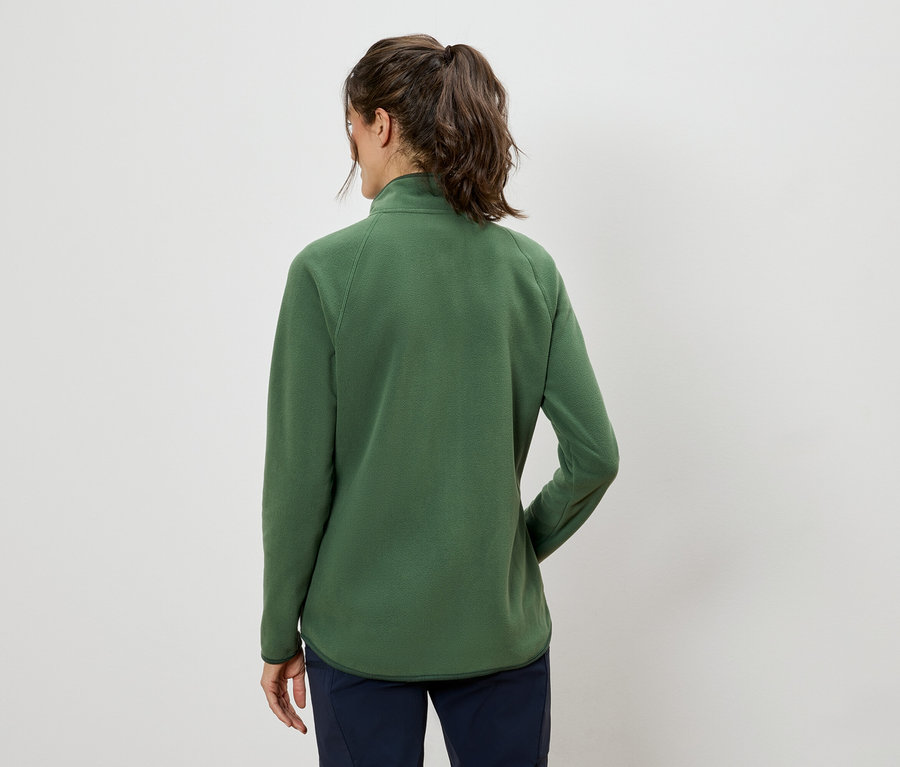 Rückansicht einer Frau mit Pferdeschwanz, die eine grüne Fleecejacke und marineblaue Hosen trägt.
