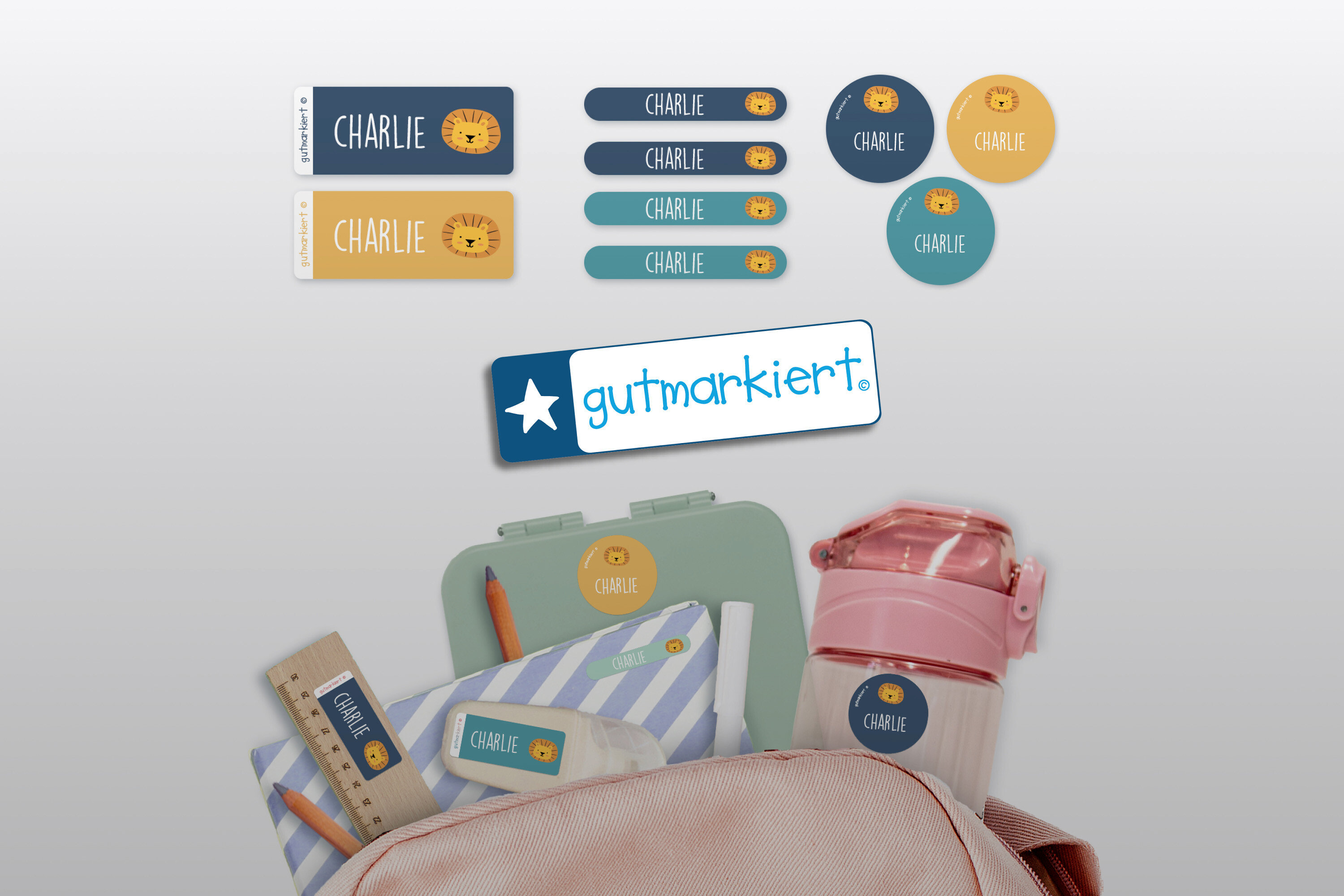 Aufkleber mit dem Namen Charlie und einem Löwenbild auf verschiedenen Gegenständen wie einer Lunchbox, einer Wasserflasche und einem Federmäppchen.