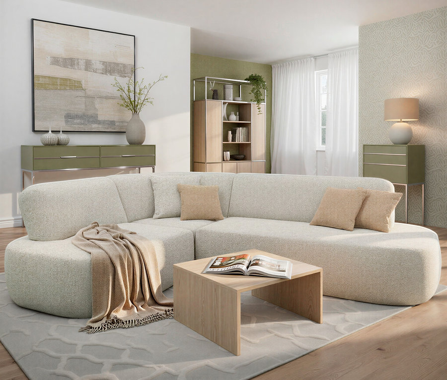 Beiges Ecksofa mit Kissen und Decke im Wohnzimmer, Couchtisch mit Buch, grüne Kommoden und Regale im Hintergrund.