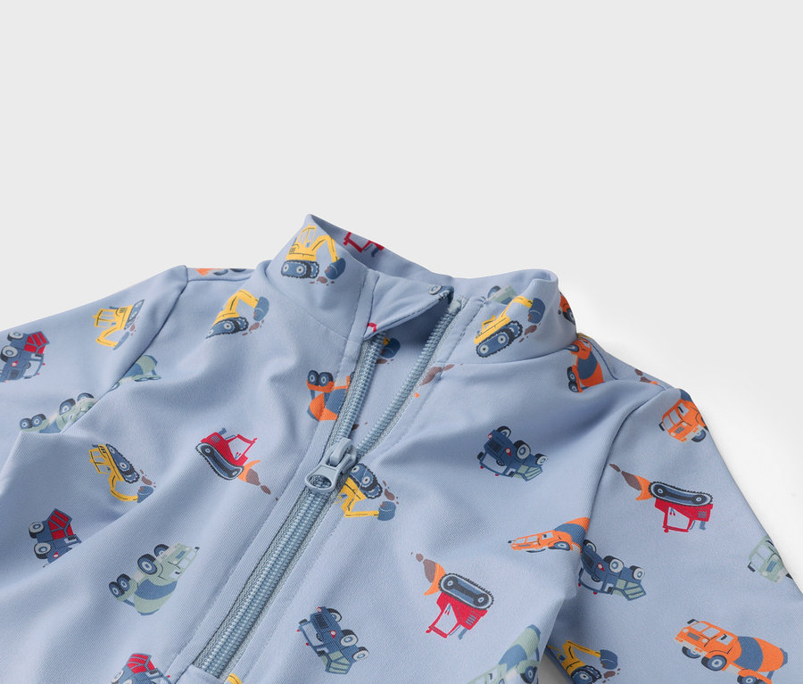 Hellblauer Stoff mit Reißverschluss und verschiedenfarbigen Bauwagen-Motiven.