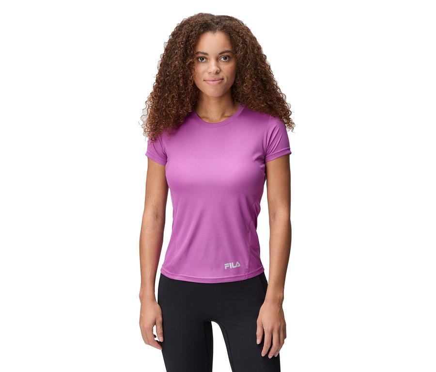 Frau mit lockigem Haar trägt ein lila FILA Damen-Funktionsshirt und schwarze Leggings.