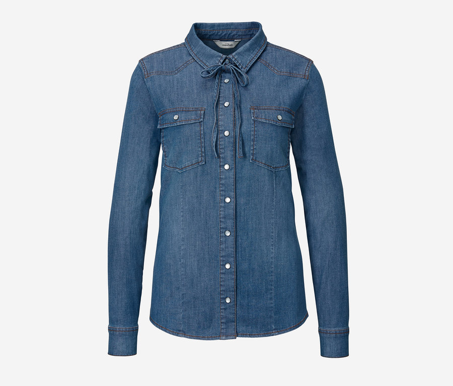 Eine blaue Jeansbluse mit langen Ärmeln, Knöpfen und einem Bindeband am Hals.