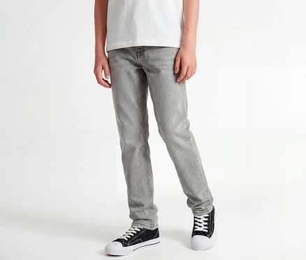 Stehende Person in weißem T-Shirt, grauen Jack&Jones JJOriginal Chris Jeans und schwarzen Sneakers.