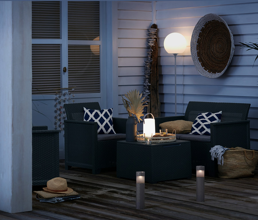 Terrasse mit geflochtenen Gartenmöbeln, LED-Leuchten und 3 Solar-Säulen.