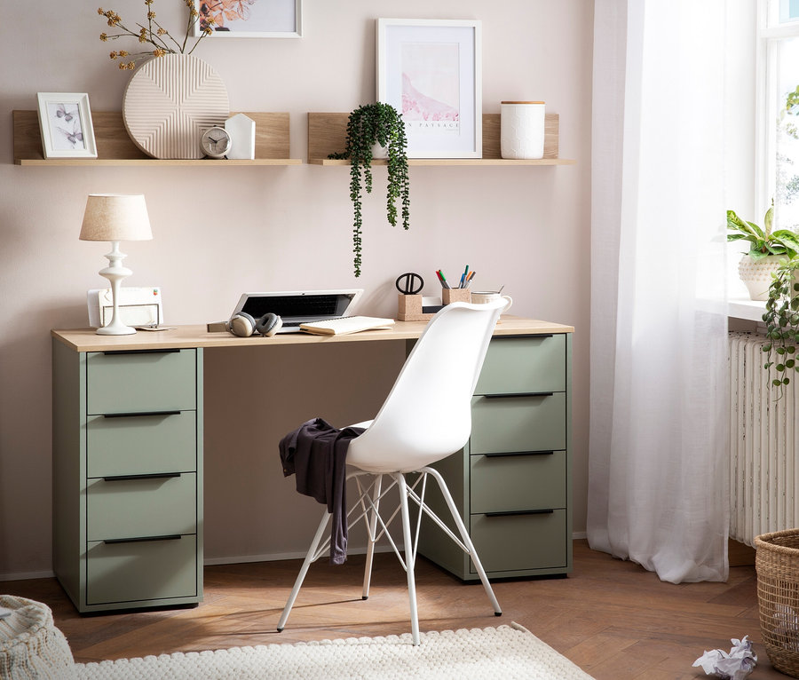 Ein pistazienfarbener Schreibtisch »Elma« mit Regalablage »Elma« und ein weißer Stuhl in einem Zimmer.