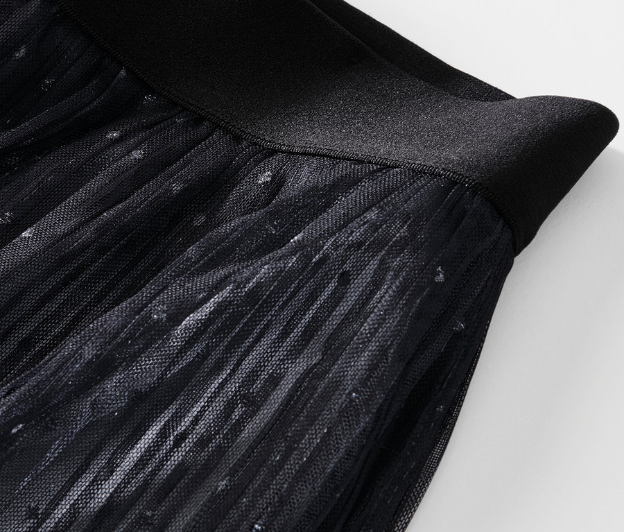 Detailansicht eines plissierten Tüllrocks mit Farbverlauf.