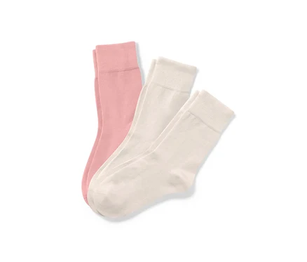 Drei Paar helle Socken liegen auf einem weißen Hintergrund.