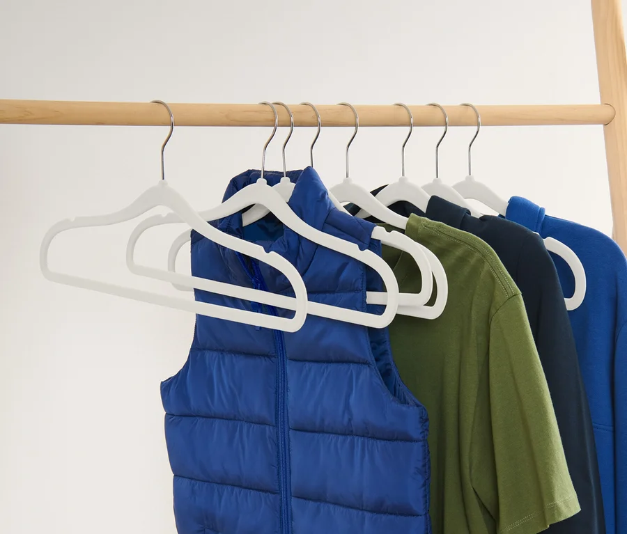 Eine blaue Weste und ein grünes, dunkelblaues und blaues T-Shirt hängen an 8 extraschmalen Kleiderbügeln.