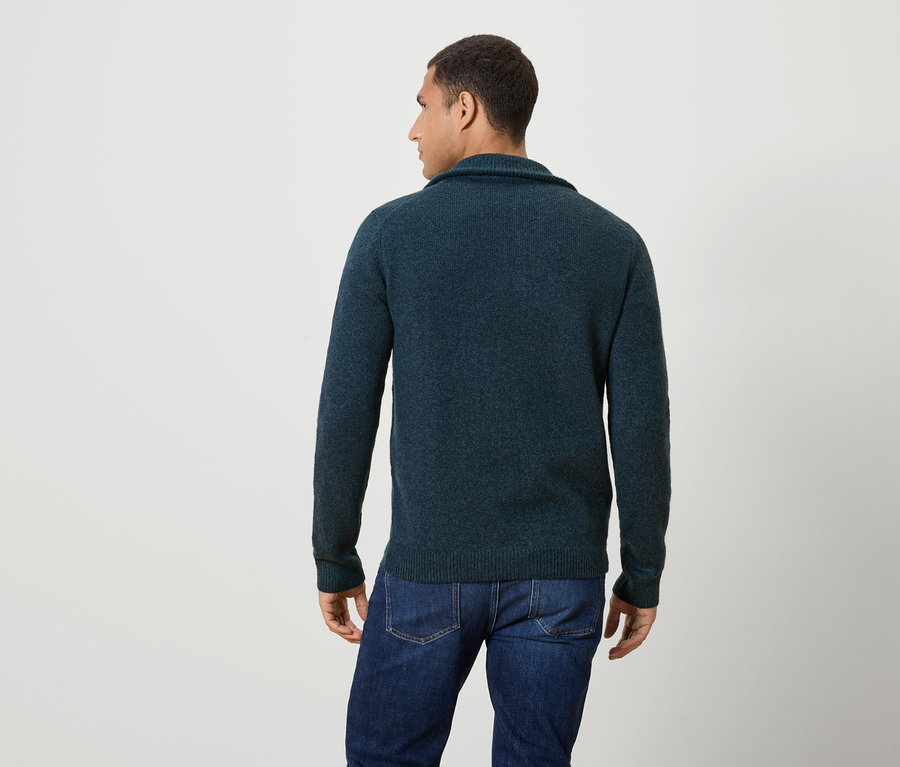 Mann von hinten, trägt einen dunkelblauen Pullover und Jeans.
