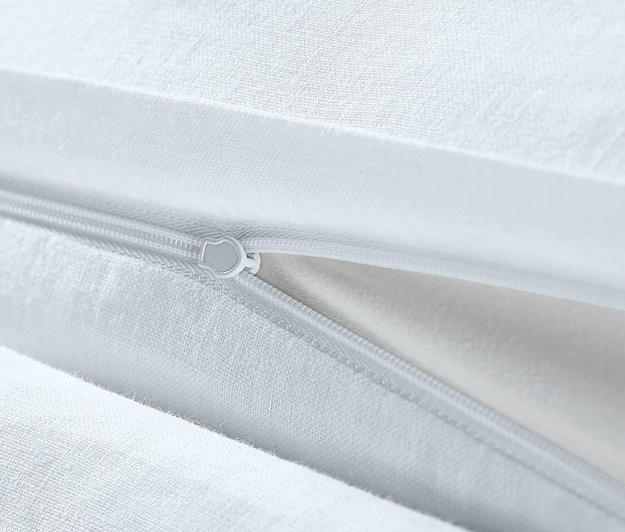 Detailaufnahme von weißer Leinen-Bettwäsche in Übergröße mit Reißverschluss.