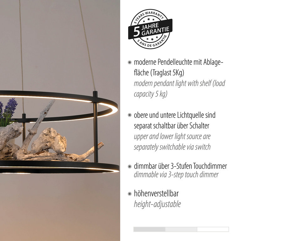 Eine moderne schwarze Hängeleuchte mit einem Regal, das mit Treibholz und lila Blumen geschmückt ist.