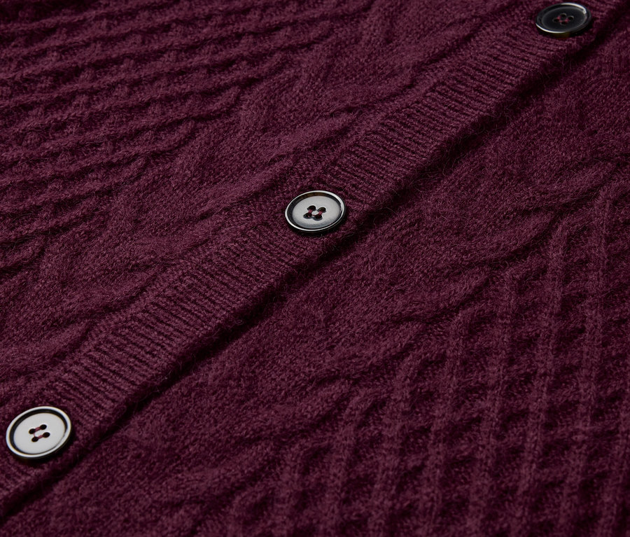 Detailansicht einer bordeauxroten Strickjacke mit Knöpfen.