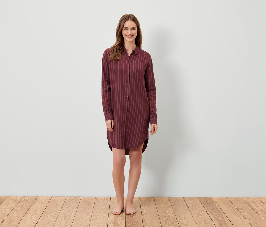 Eine Frau steht und trägt ein weinrotes gestreiftes Hemdkleid.