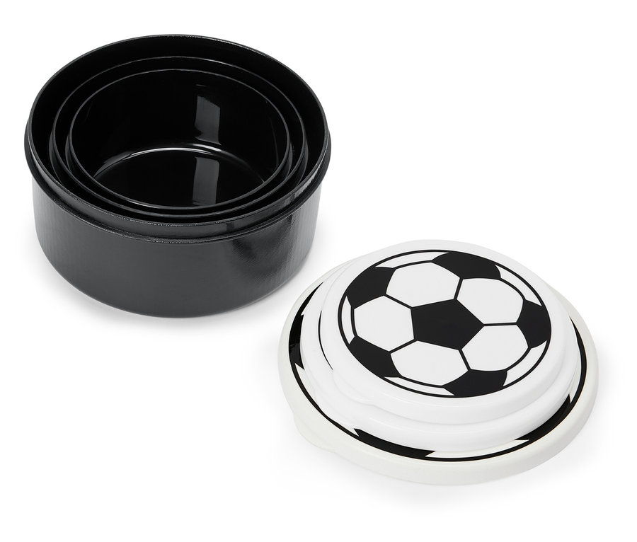 Drei schwarze, ineinander gestapelte Schalen und ein weißer Deckel mit Fußballmuster.