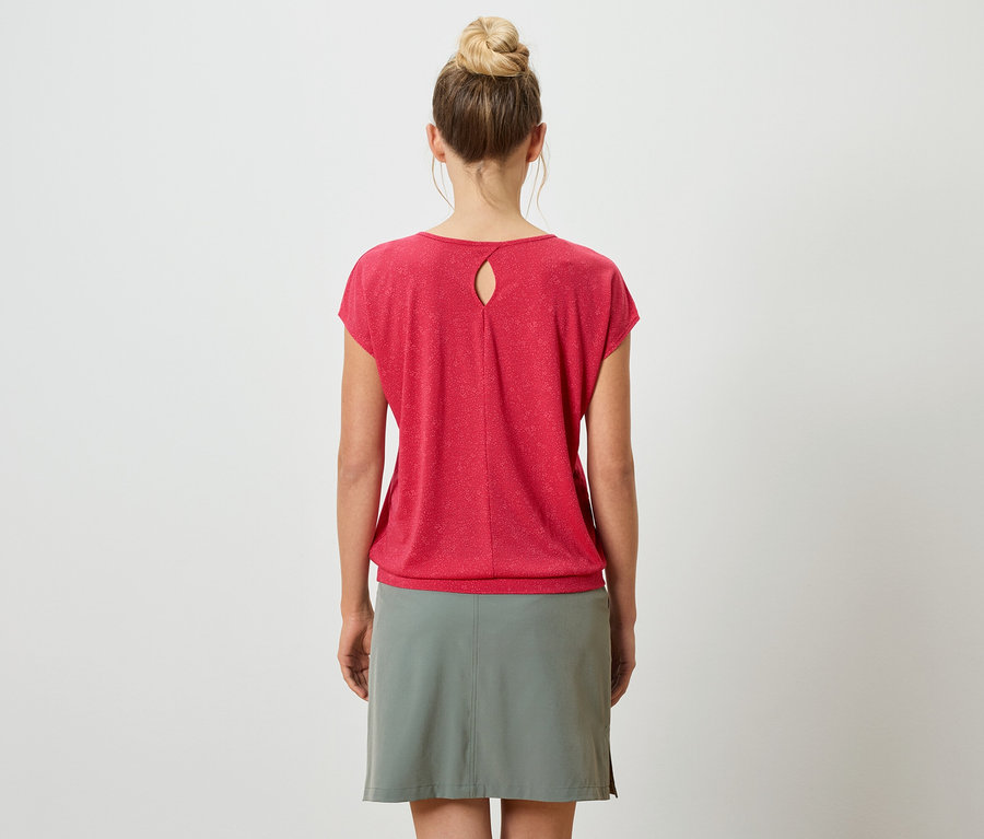 Rückansicht einer Frau mit Duttfrisur, die ein rotes T-Shirt mit Schlüssellochausschnitt und einen grauen Rock vor einem weißen Hintergrund trägt.