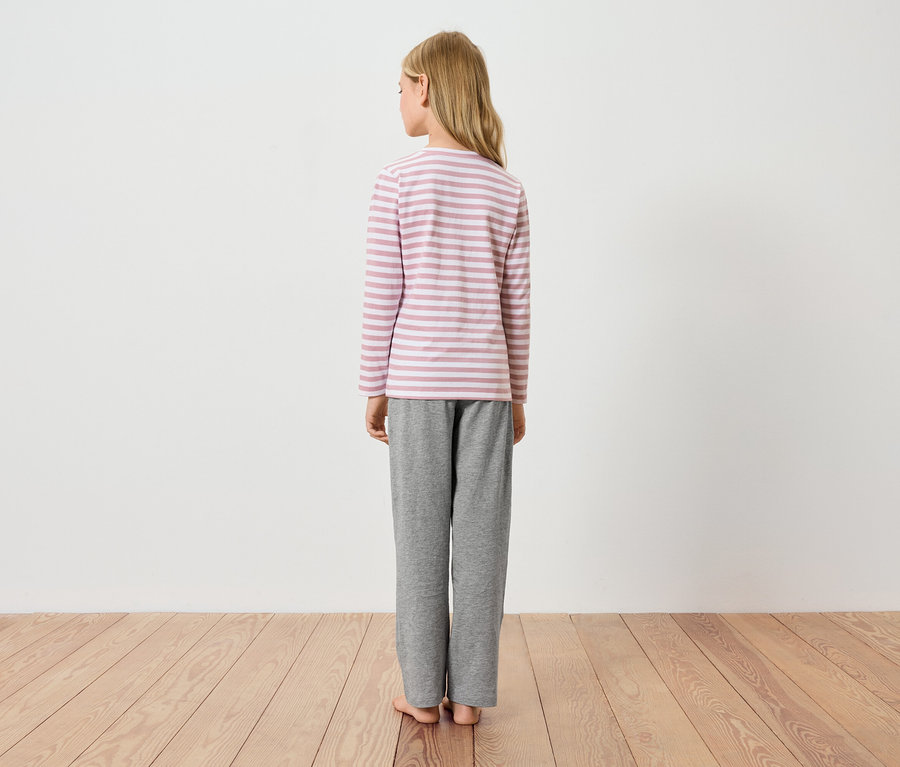 Mädchen von hinten, trägt ein gestreiftes Langarmshirt und graue Hosen.