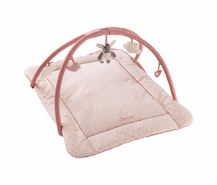 Rosa Baby-Spielmatte mit Spielbogen. Die hellrosa Matte hat kleine rosa Punkte und einen dunkelrosa Rand. Am rosa Bogen hängen ein grauer Esel, zwei weiße Wolken, ein rosa Wal und ein rosa Herz.