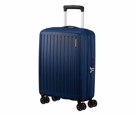 Ein kleiner, navyblauer American Tourister #Rejoy Spinner# Koffer steht aufrecht. Er hat eine geriffelte Oberfläche, einen ausziehbaren Griff, vier Doppelrollen und ein integriertes Zahlenschloss.