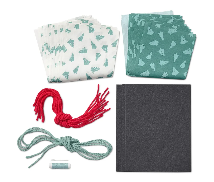 Näh-Set »Stoff-Adventskalender« mit weißen und grünen Stoffen, roter und blauer Schnur und schwarzen Karten.