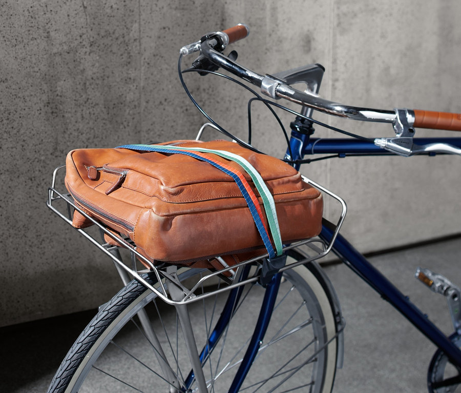 Eine braune Ledertasche ist an einem Fahrrad-Vorderrad-Gepäckträger befestigt.