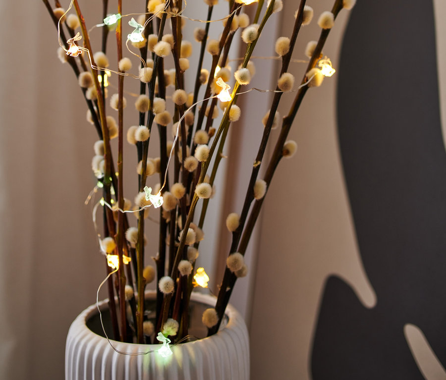 Kätzchenweidenzweige in Vase mit LED-Micro-Lichterkette mit Häschen.