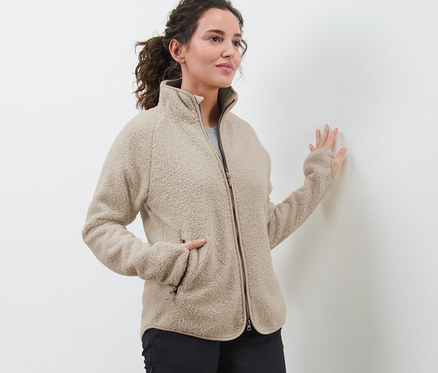 Frau trägt eine beige Teddyfleece-Jacke.
