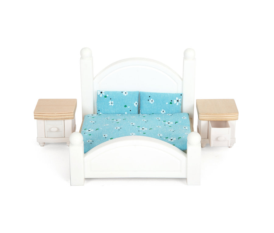 Weißes Bett mit blau-geblümter Bettwäsche und zwei Nachttischen.