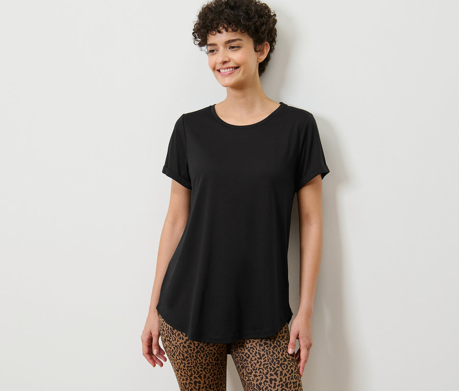 Frau posiert in einem schwarzen Longshirt.