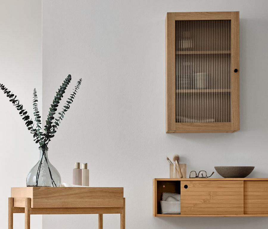 Badezimmer mit Handtuchständer aus Massivholz, Standregal mit 3 Fächern (mit Handtüchern und Deko), Wandregal mit Schiebetüren (mit Badaccessoires) und Wandschrank mit Riffelglastür.