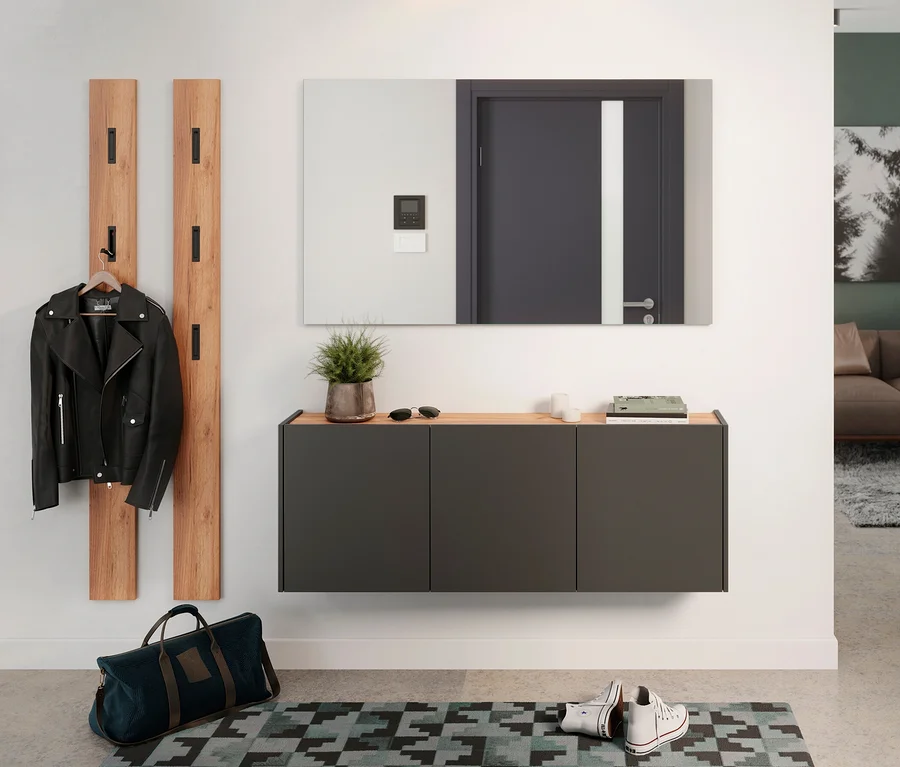 Eingangsbereich mit graphitfarbenem Mehrzweckschrank »Libbiano«, Spiegel, Garderobenpaneelen, Jacke und Tasche.