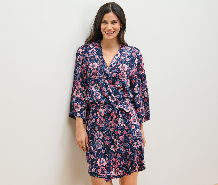 Frau trägt einen Web-Morgenmantel mit Blumenmuster.