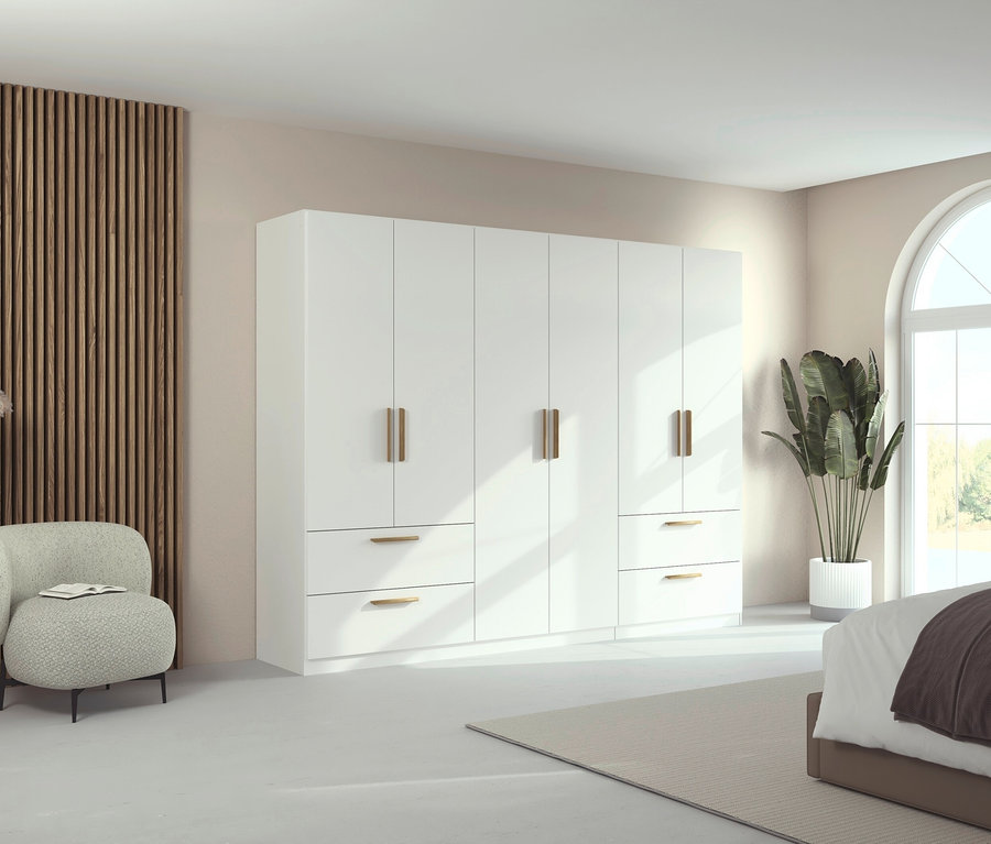 Ein Zimmer mit einem weißen, 6-türigen Drehtürenschrank »Skandi« von Rauch und einem Sessel.