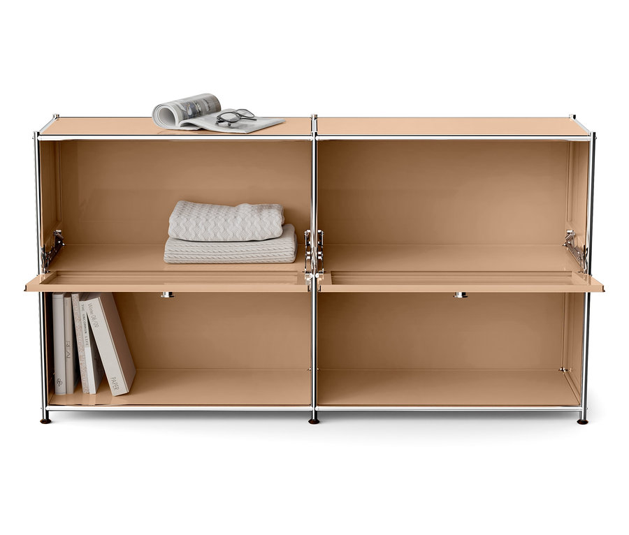 Beiger Schrank mit vier Fächern, von denen zwei offene Türen haben. Oben liegen eine Decke, eine Zeitung und eine Brille, unten Bücher.