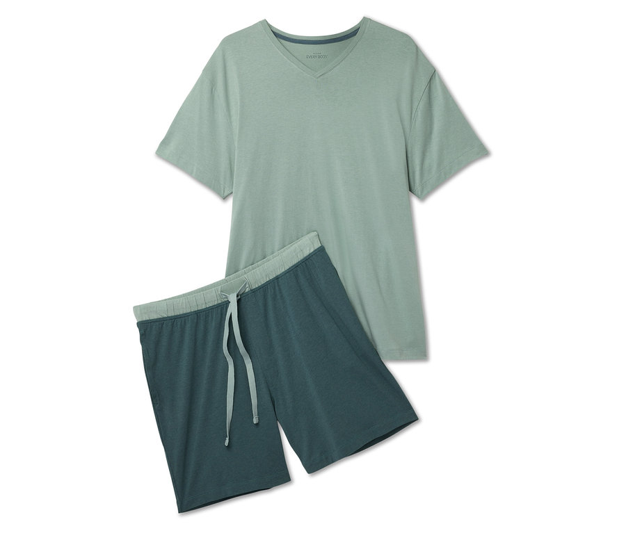 Ein hellgrünes T-Shirt und dunkelblaue Shorts mit Kordelzug liegen auf einem weißen Hintergrund.