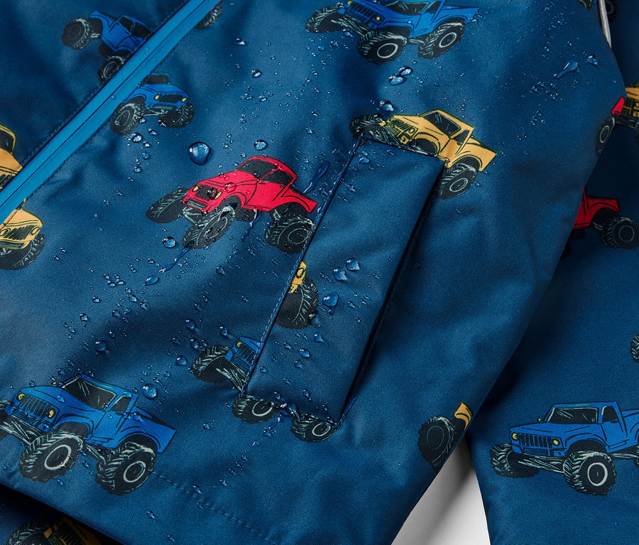 Detailansicht einer Kinder-Thermo-Regenjacke mit Monstertruck-Muster.