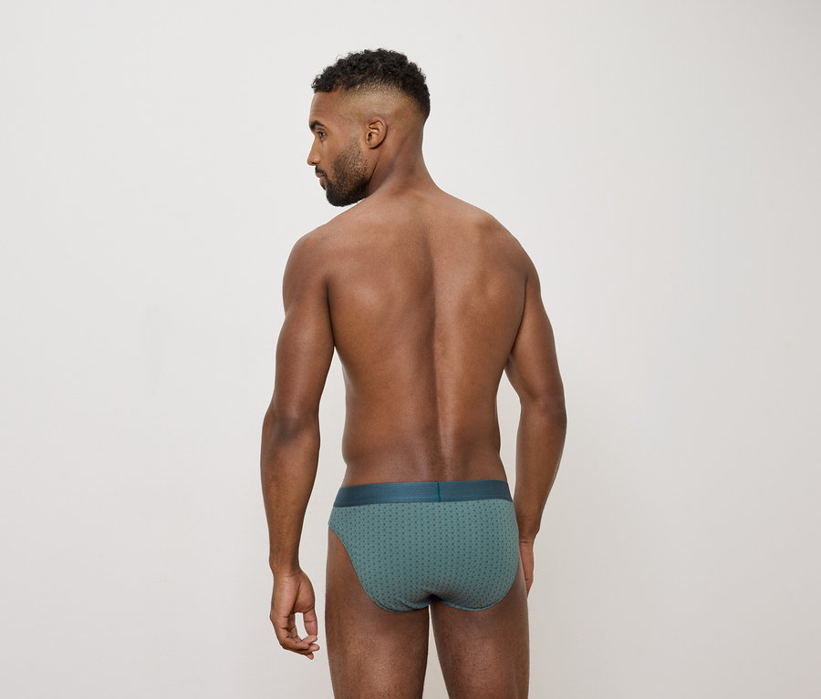 Mann von hinten trägt grüne Slips.