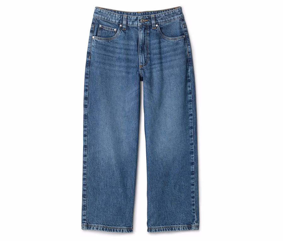 Eine einzelne, hellblaue Jeans mit weitem Bein liegt auf einem weißen Hintergrund.
