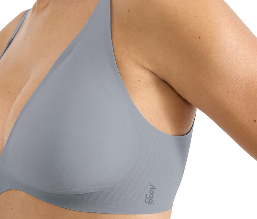 Nahaufnahme einer Frau, die einen grauen Sloggi BH trägt.