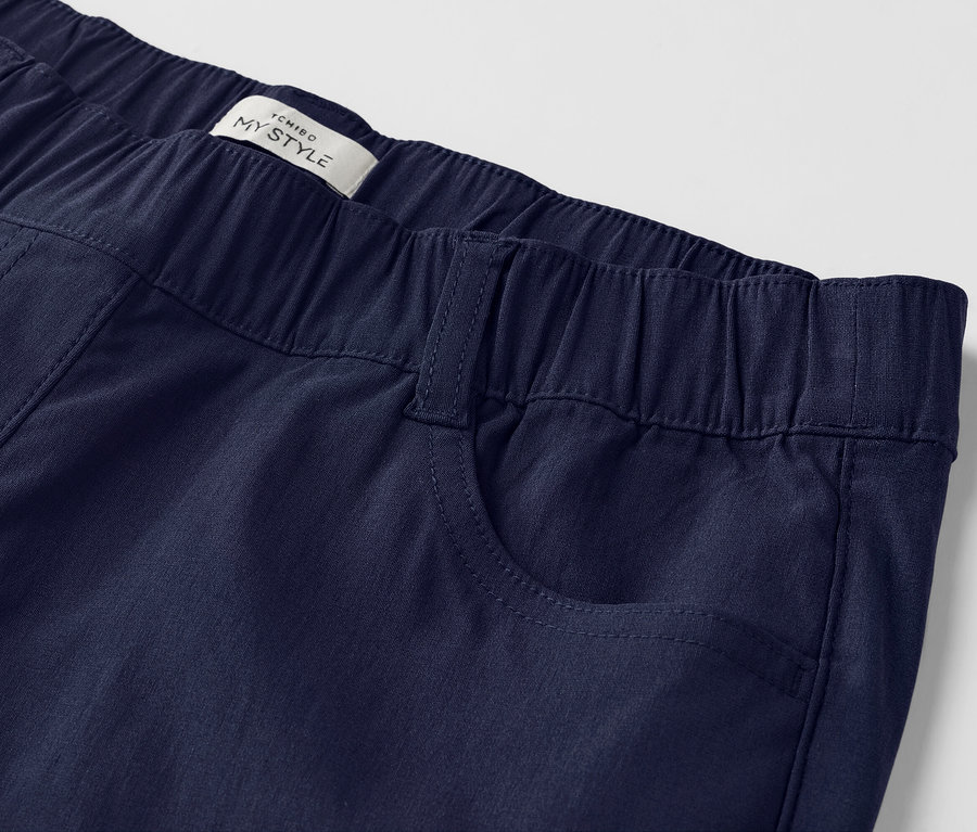 Nahaufnahme einer marineblauen Hose mit Gummibund und aufgenähten Taschen.