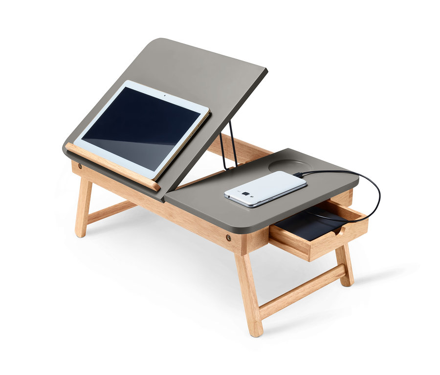 Grauer Betttisch mit geneigter Tischplatte, auf der sich ein Tablet befindet, und einer Schublade mit einem aufladenden Telefon.