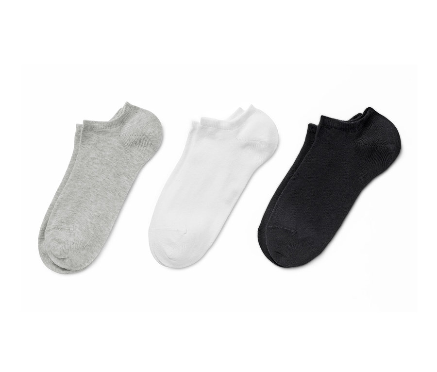 Drei Paar unifarbene Sneakersocken: grau, weiß und schwarz.