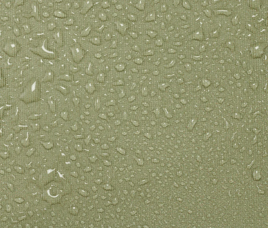 Detailansicht eines karierten Outdoor-Kissens, das mit Wassertropfen bedeckt ist.