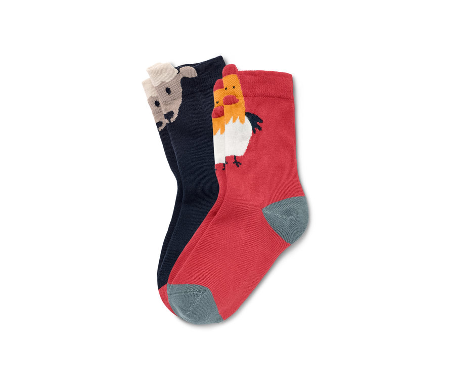 Zwei Paar 3D-Kleinkind-Socken. Ein Paar ist dunkelblau mit einem Schafmotiv, das andere rot mit einem Hahnmotiv.