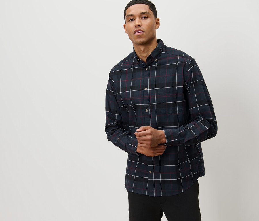 Mann posiert in marineblauem Flanell-Hemd.
